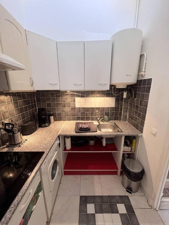 une petite cuisine avec des armoires blanches et un évier dans l'établissement Joli studio cabine en face de la Mer wifi et terrasse 4AJOU148, à Canet