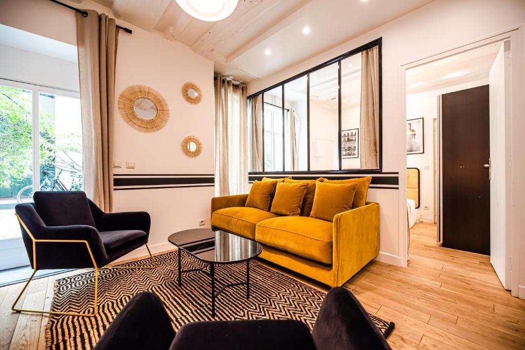 - un salon avec un canapé jaune et deux chaises dans l'établissement CIA - Bastille Coziness, à Paris