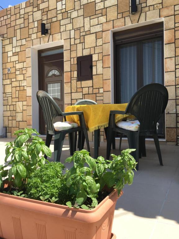 a patio with chairs and a table and some lettuce at Stone House Retreat in Kalavárda