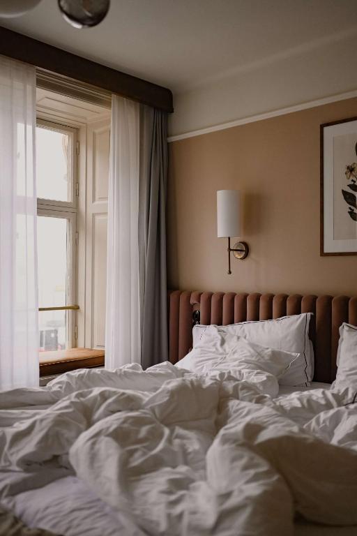 an unmade bed in a bedroom with a window at Hotel Frantz, WorldHotels Crafted in Stockholm