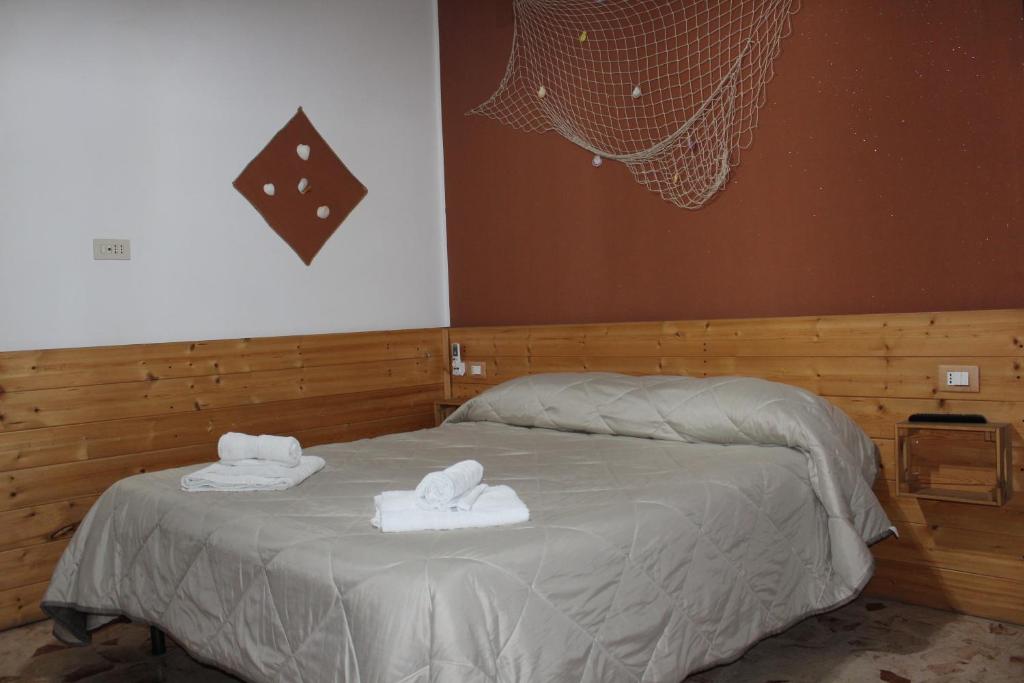 Postel nebo postele na pokoji v ubytování Nettuno Rooms