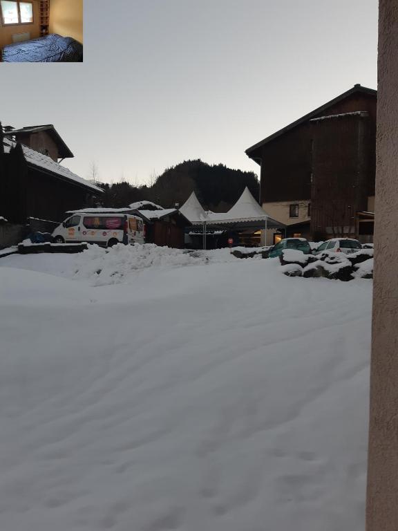 un parking couvert de neige avec des voitures garées dans l'établissement Appartement Morillon 500m ski et randonnée, à Morillon