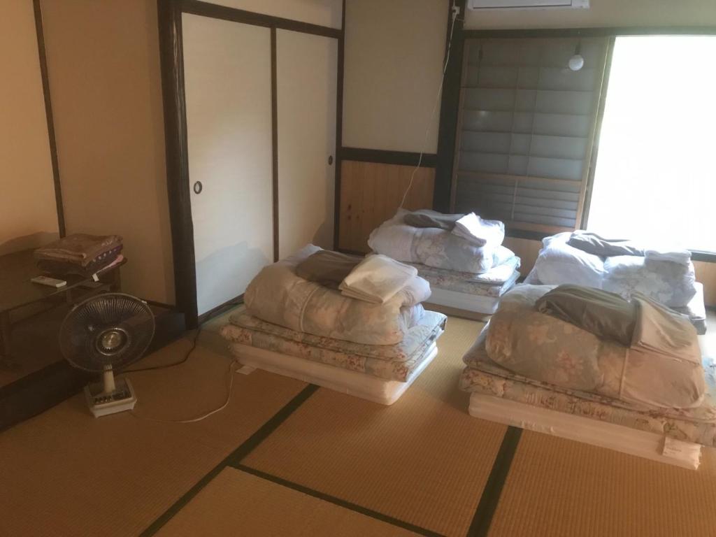 a room with three beds and a fan at Onjuku ikkyu - Vacation STAY 14021v in Hongu
