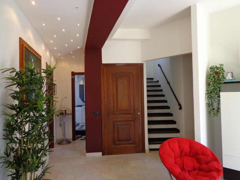 a hallway with a red chair and stairs at Appartamento Ogliastra in Lanusei