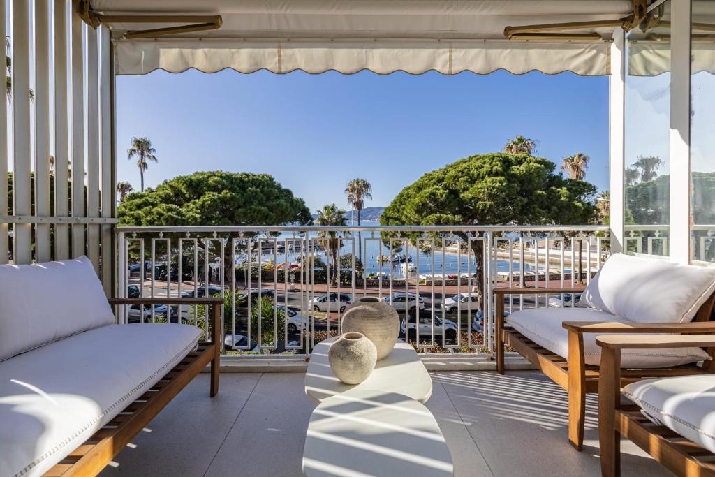 - un balcon avec des lits et une vue sur l'océan dans l'établissement REF 1979 - Cannes Palm beach- Sea view apartment for rent, à Cannes
