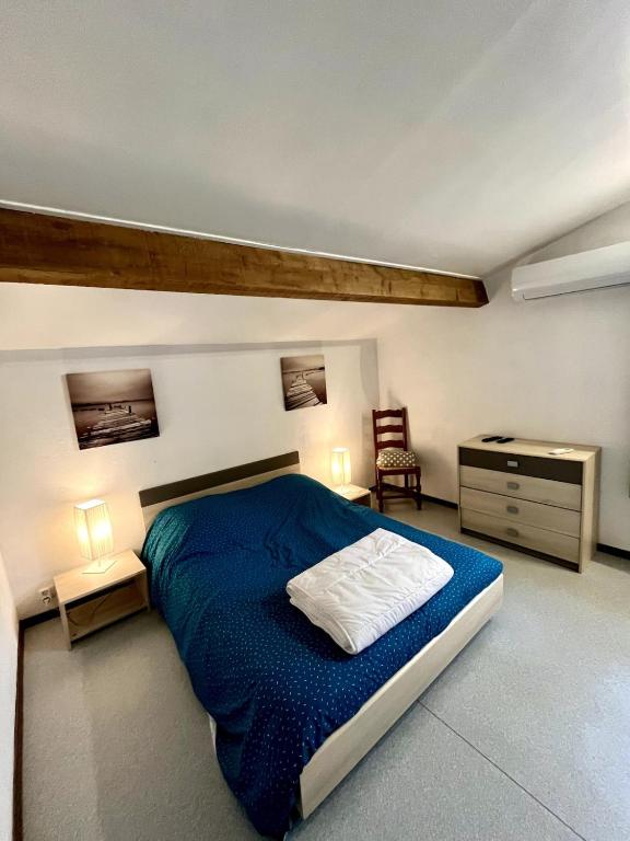 - une chambre avec un lit bleu et un bureau dans l'établissement Studio Les Tilleuls, à Pouilly-les-Nonains