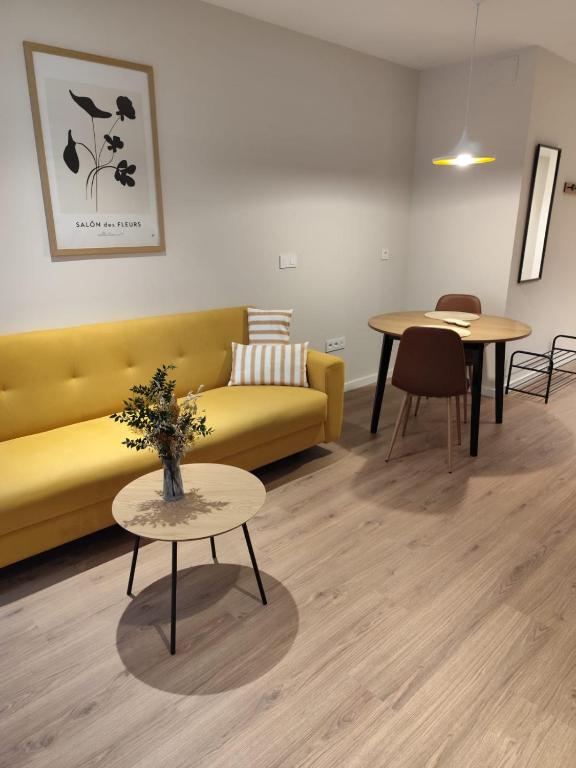 a living room with a yellow couch and a table at Bazan51 1 in Alicante