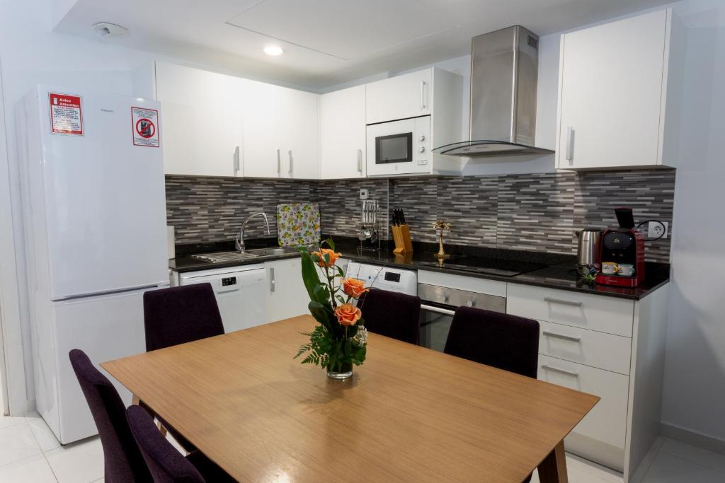 a kitchen with a wooden table with a vase of flowers on it at Calpe Beach in Calpe
