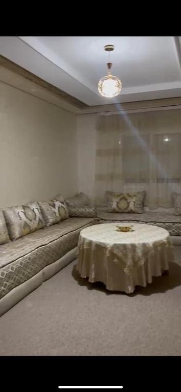 a living room with a table and a couch at plateau appartement safi in Safi