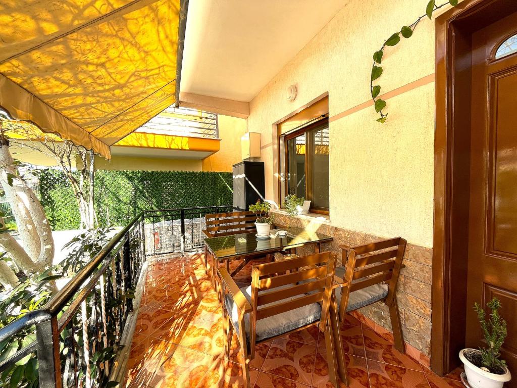 a balcony with a dining table and chairs on a patio at Beach & Chill Apartments in Vlorë
