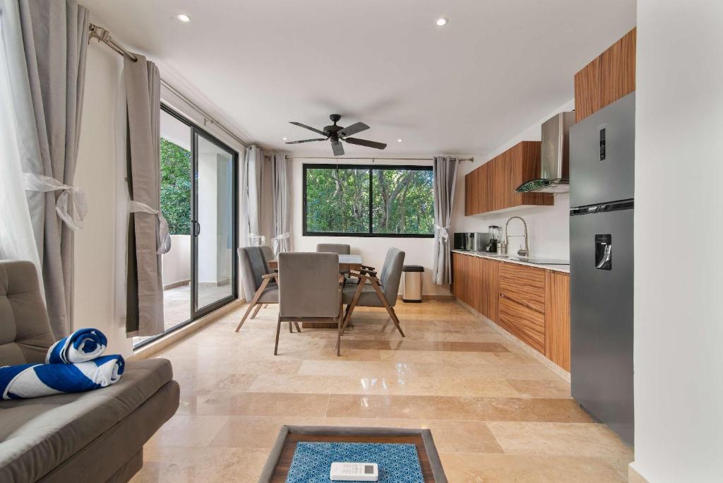 a kitchen and living room with a couch and a table at Aldea Zama 2-BR Lux Building Amenities in Tulum