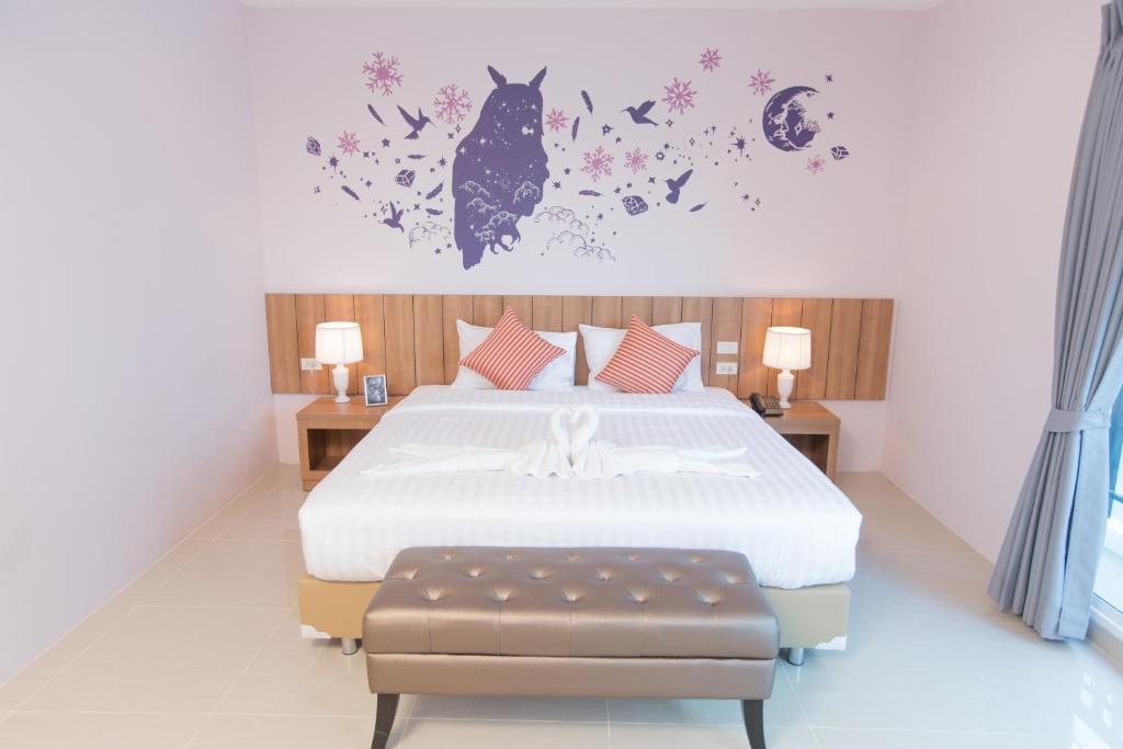 1 dormitorio con 1 cama con flores y un gato en la pared en The Bedroom Ladprao 101 Bangkok - SHA, en Bangkok