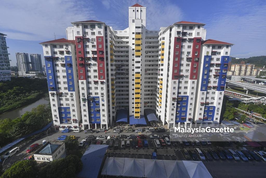 a group of tall buildings with cars in a parking lot at Homestay Ria in Kuala Lumpur
