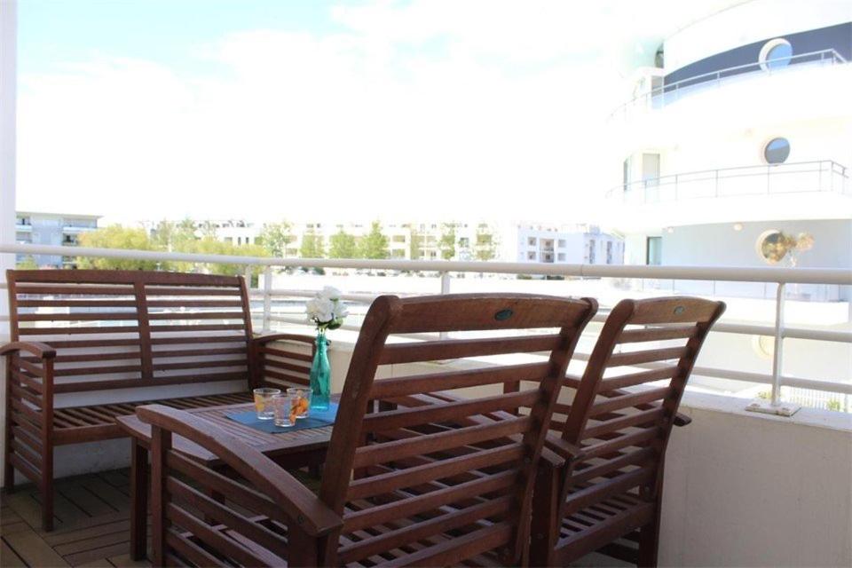 - une table et des chaises sur un balcon avec un bateau dans l'établissement Appt 2 pièces LA ROCHELLE - LR030-E121, à La Rochelle