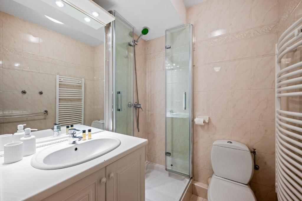 une salle de bain avec un lavabo, une douche et des toilettes dans l'établissement Admiral Plaza, appartement 1 chambre en centre ville, parking & accès plage, à Menton