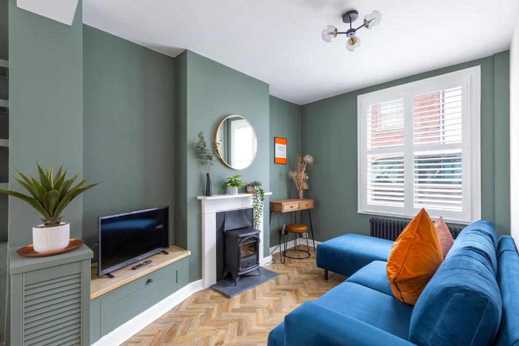 a living room with a blue couch and a tv at Queens Gardens in Brighton & Hove