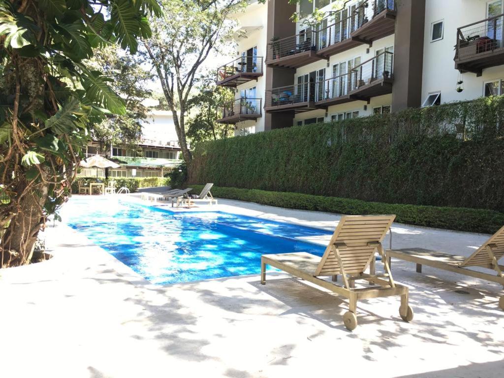 a swimming pool with two lounge chairs next to a building at Brisa de rio Apartamento in La Chimba