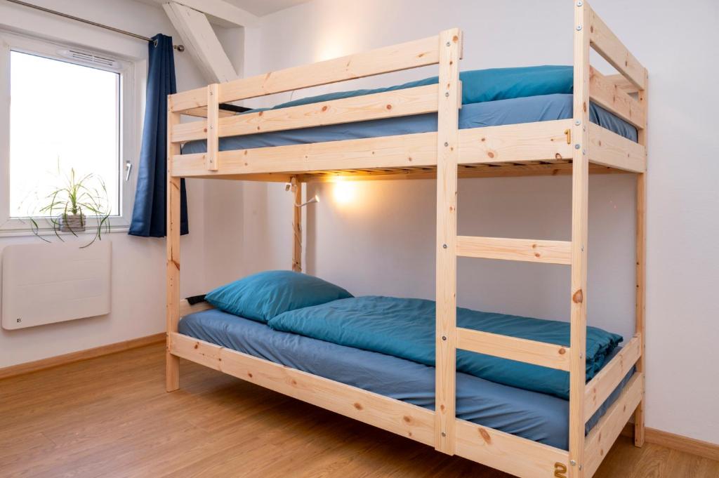 Etagenbett mit blauen Kissen in einem Zimmer in der Unterkunft Bretzel Bed Petite Venise Bed in Shared room City Center Wi-Fi in Colmar