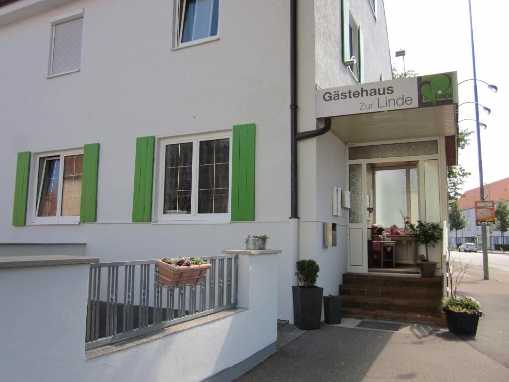 a white building with a sign on the side of it at Gästehaus zur Linde in Ingolstadt