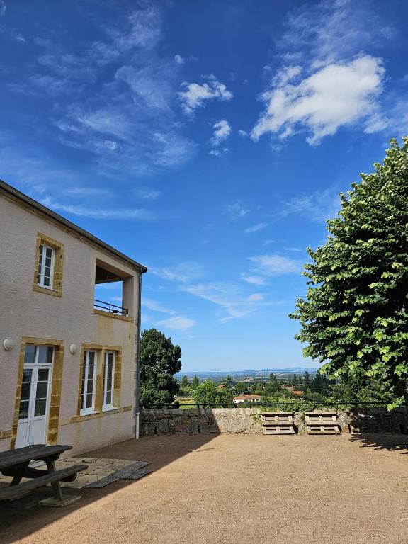 - un bâtiment avec une table de pique-nique à côté d'un arbre dans l'établissement Chambres d'Hôtes La Courlande, à Saint-Haon-le-Vieux