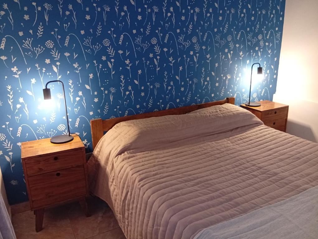 - une chambre avec un lit et un mur bleu orné de papillons dans l'établissement Departamento Parque Norte, à San Rafael