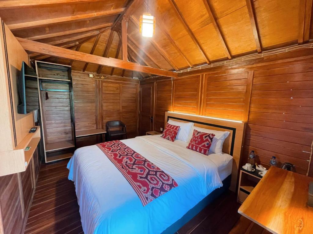 a bedroom with a bed in a room with wooden walls at Naraya Nusantara Resort & Kafe in Sepaku