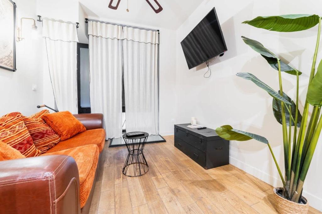 un salon avec un canapé et une télévision dans l'établissement Appartement au coeur Paris 9 moulin rouge - FLAT-GUEST, à Paris