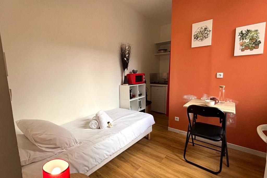 une chambre avec un lit, une table et une chaise dans l'établissement La Studette - Deux pas du quartier Gratte-Ciel, à Villeurbanne