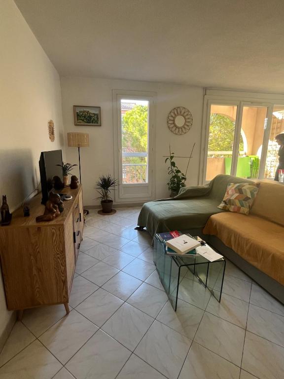 un salon avec un canapé et une table dans l'établissement Appt Lumineux, Terrasse Parking privé, à Montpellier