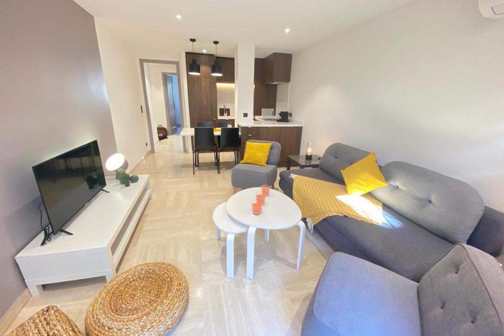 a living room with a blue couch and a tv at Renovated 2 bedrooms - Boulevard de la Croisette in Cannes