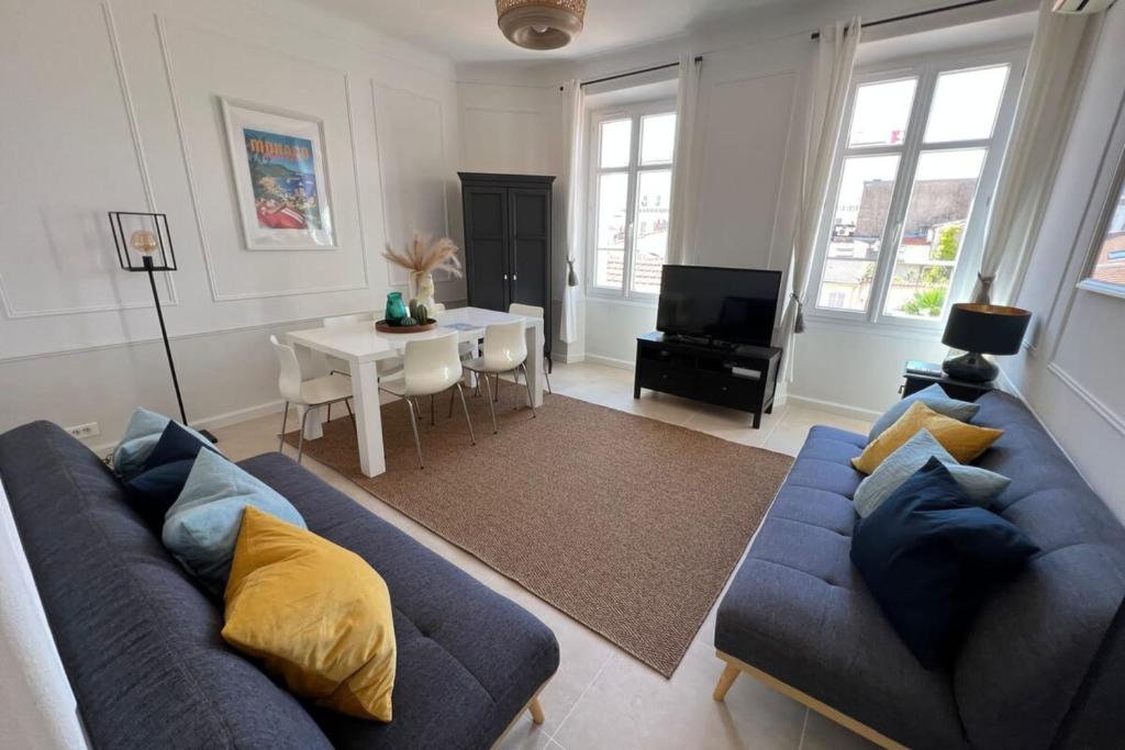 un salon avec un canapé bleu et une table dans l'établissement Nice 2 bedrooms Meynadier at 2 min BeachPalais, à Cannes