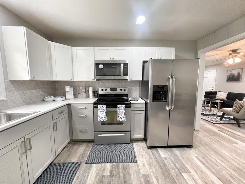 Una cocina con gabinetes blancos y un refrigerador de acero inoxidable. en Family-friendly Decatur Oasis, en Decatur