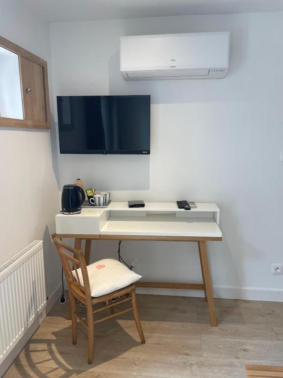 Elle comprend un bureau avec une chaise et une télévision murale. dans l'établissement Le Déo, à Pommiers