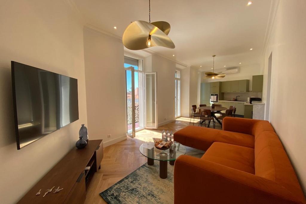 un salon avec un canapé orange et une télévision dans l'établissement New apartment in Forville with balcony, à Cannes