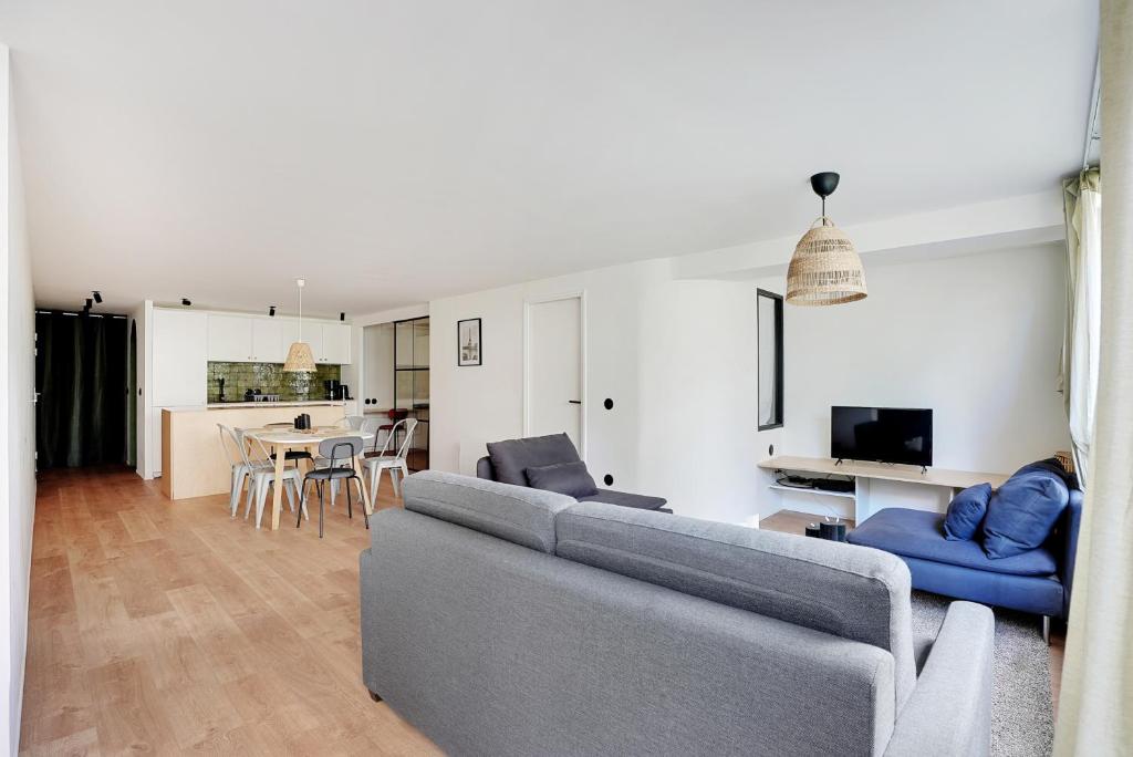 un salon avec un canapé et une salle à manger dans l'établissement Appartement équipé - Parking - Proche commerces, à Rosny-sous-Bois