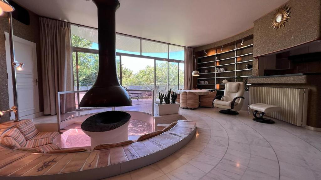 une grande chambre avec une cheminée au milieu de celle-ci dans l'établissement Le Seventies, à Bouzigues