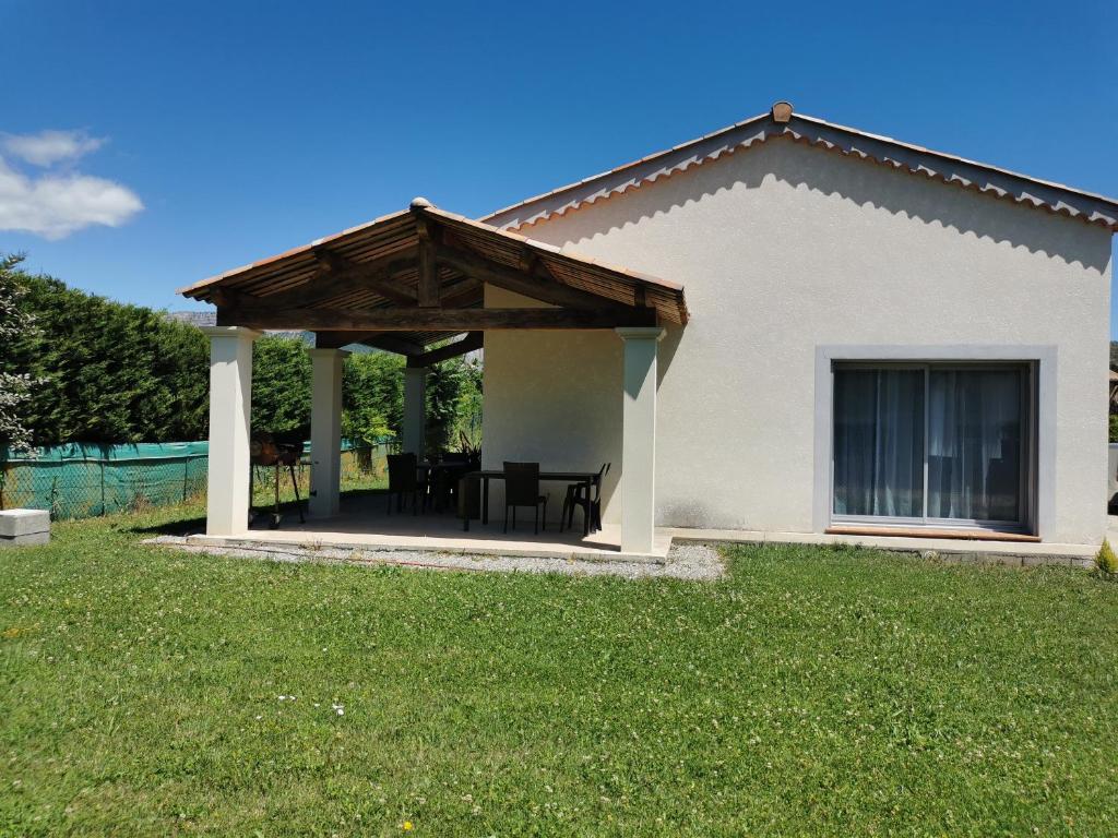 a pavilion with a table and chairs in a yard at La Maison De Titou in Lazer