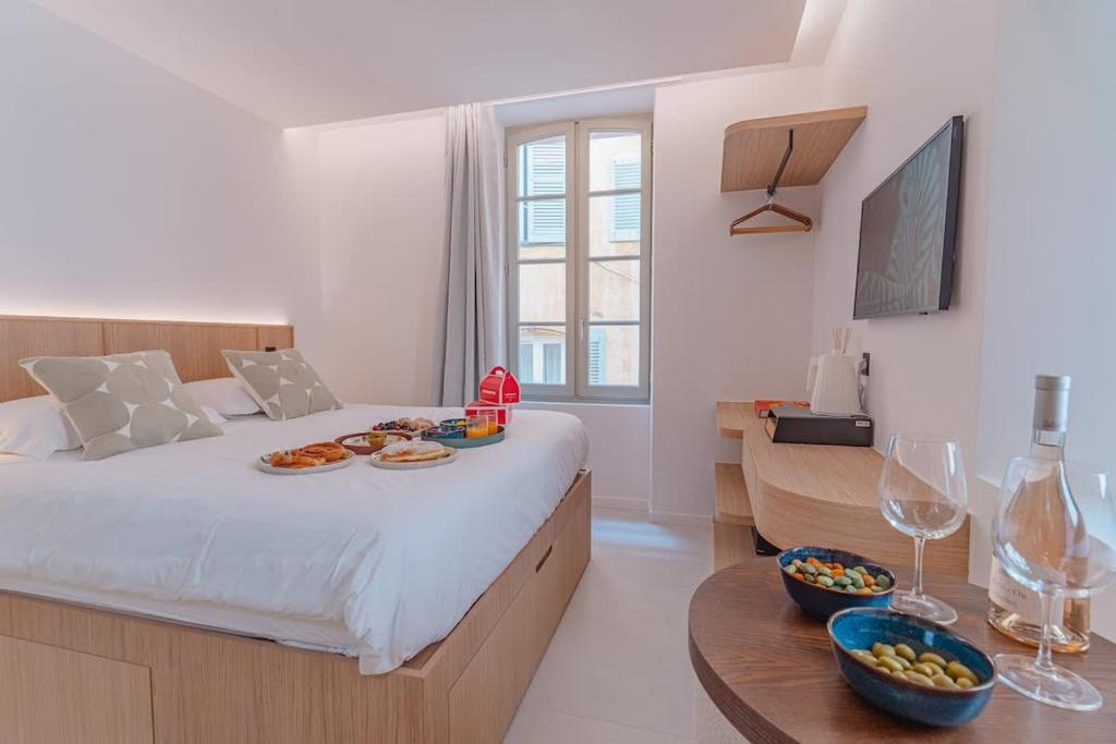 - une chambre dotée d'un lit avec des assiettes de nourriture et des verres à vin dans l'établissement The Bell Tower l In Old Village l Shellter Rentals, à Saint-Tropez