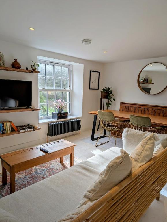 a living room with a couch and a table at Ramble & Rye - The Nest in Talland
