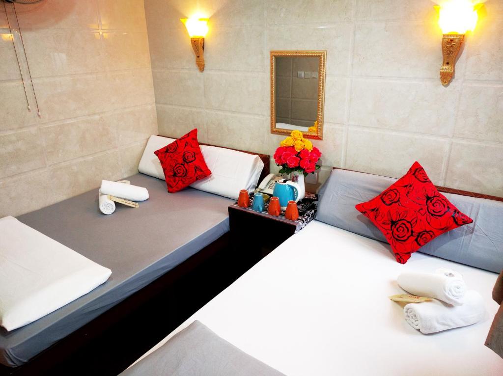 2 łóżka w pokoju z czerwonymi poduszkami w obiekcie Days Hostel Block D w Hongkongu
