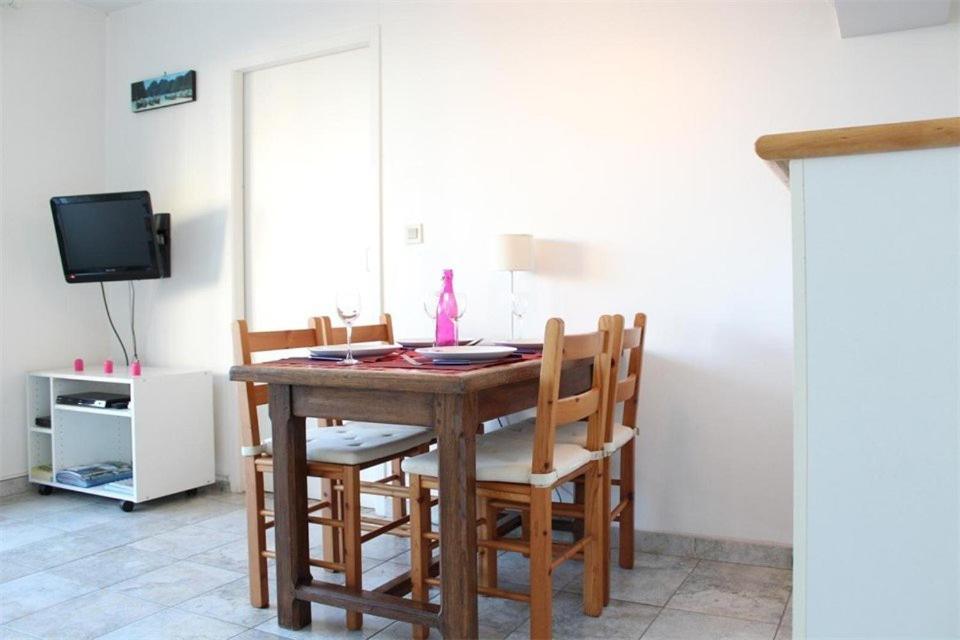 une table à manger avec des chaises et une télévision dans l'établissement Appt 2 pièces LA ROCHELLE - LR440-003, à La Rochelle