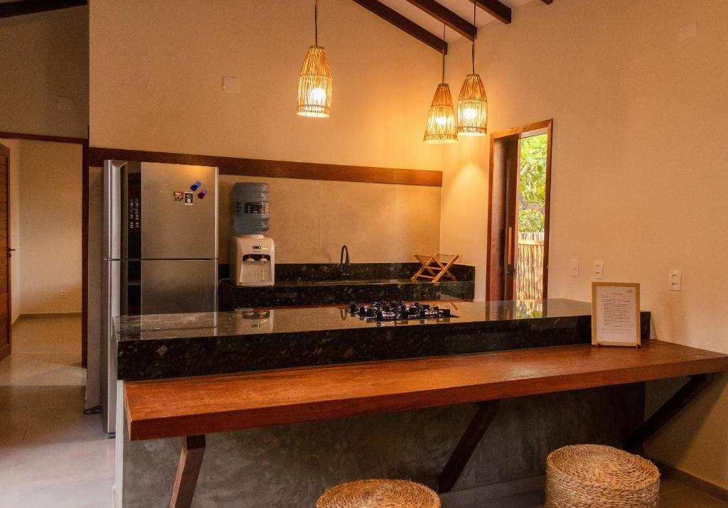 eine große Küche mit einer Theke und einem Kühlschrank in der Unterkunft Casa Aroeira em Barra Grande - Casa principal in Barra Grande