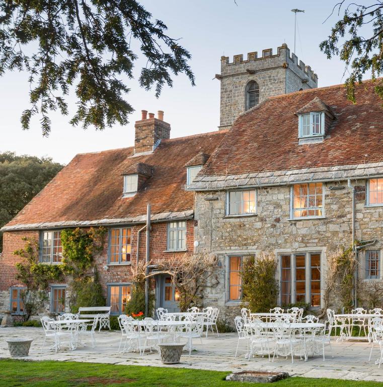 Un lugar para bodas con mesas y sillas frente a un edificio. en Priory Wareham, en Wareham
