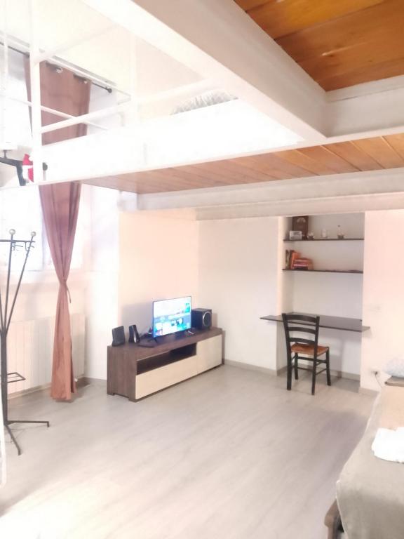 Una sala de estar con un televisor y una mesa. en Porta RomanaBocconi LeCase&Vacanze Ambrosiane, en Milán