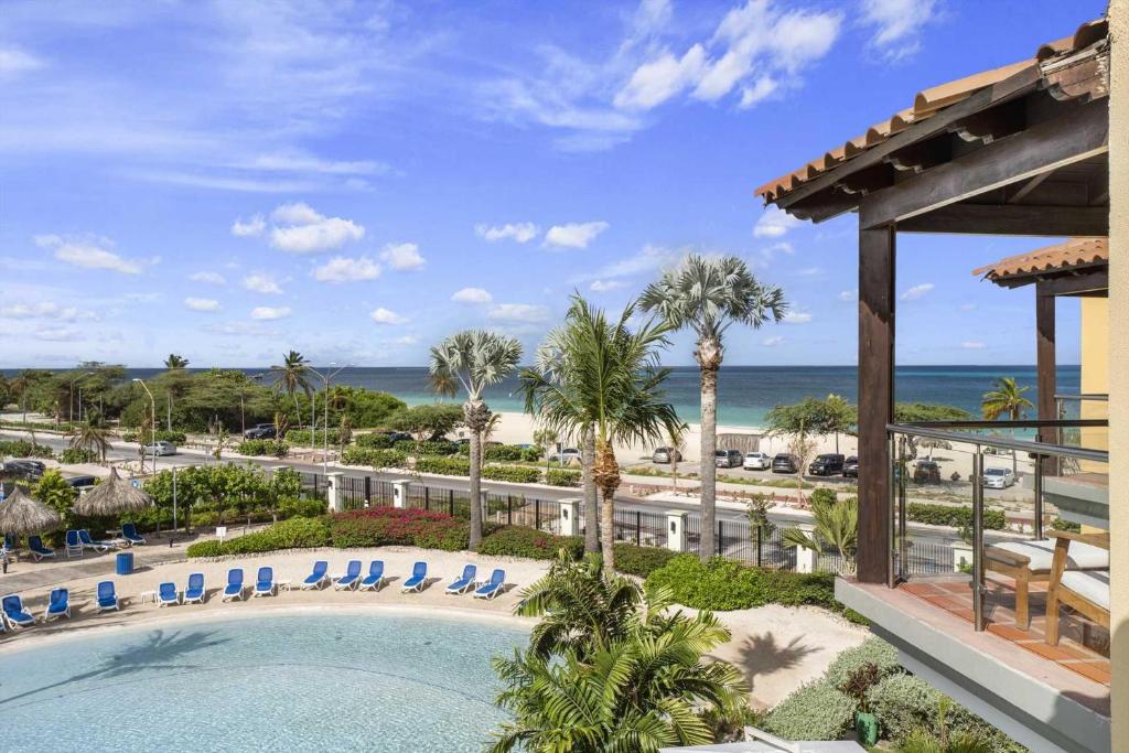 a view of the beach from the balcony of a resort at Beachfront - Eagle Beach - Sapphire 2BR condo E322 in Palm-Eagle Beach