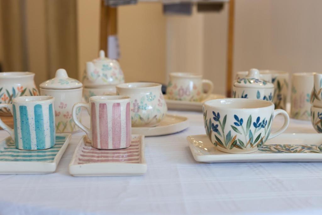 a group of cups and saucers on a table at Hotel Mediterraneo in San Miguel de Tucumán