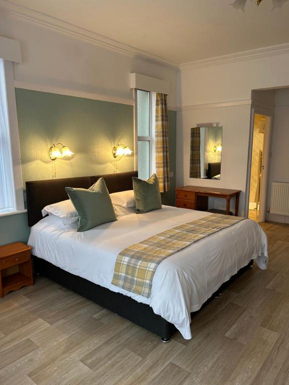 a bedroom with a large bed with two pillows at Knighton Lodge in Skegness