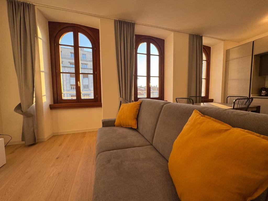 a living room with a couch and two windows at Pep's Rooms by the sea in Trieste