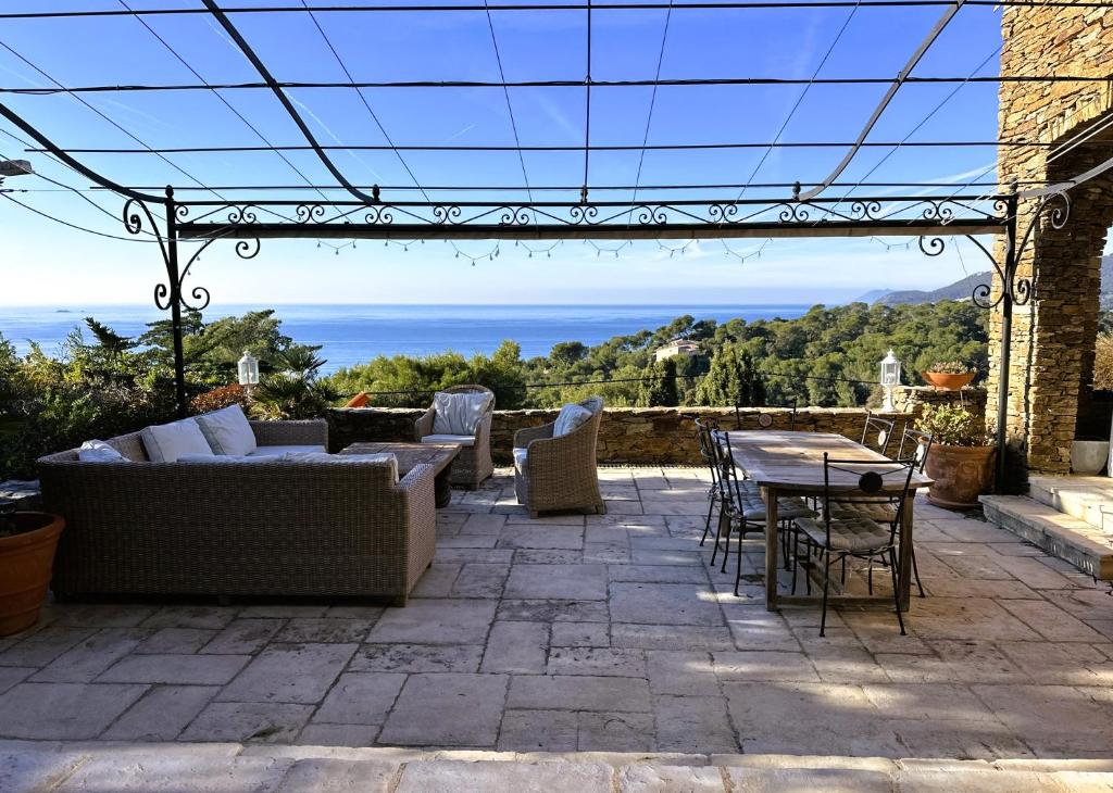 d'une terrasse avec un canapé, des chaises et une table. dans l'établissement Villa Serena climatisée pour 8 personnes avec piscine privée et vue mer à Carqueiranne, à Carqueiranne