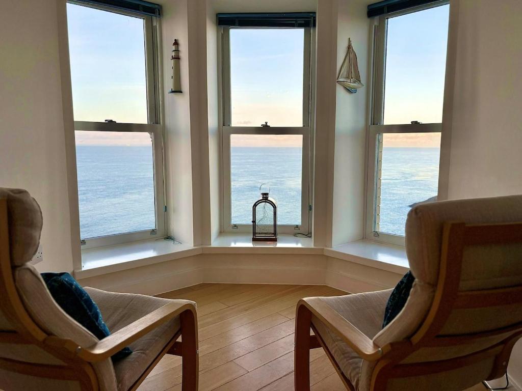 Habitación con 4 ventanas y vistas al océano. en Granville Lookout - 2 bed Apt, en Ilfracombe